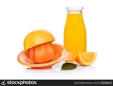 Fresh raw peeled oranges with juice squeezer and glass bottle with leaves on white background