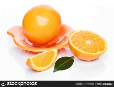 Fresh raw peeled oranges with juice squeezer with leaves on white background
