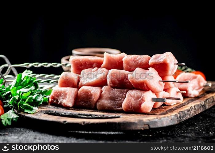 Fresh raw pork kebab on a cutting board. On a black background. High quality photo. Fresh raw pork kebab on a cutting board.