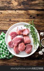 Fresh raw pork tenderloin, chopped meat on dark wooden rustic background, top view