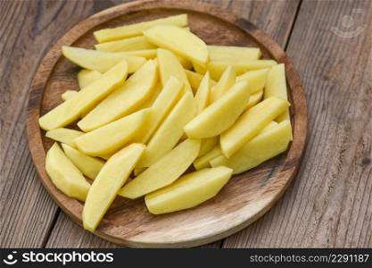 fresh raw potato wedges, chopped potatoes for cooked food on wooden bcakground