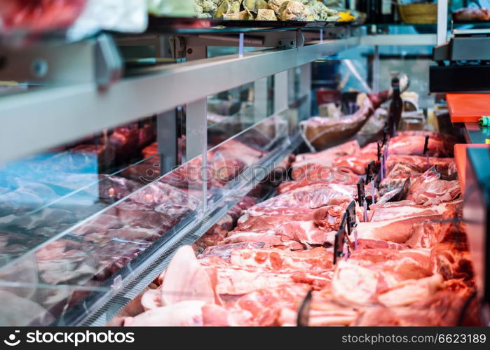 Fresh raw red meat at the butcher in refrigerated display