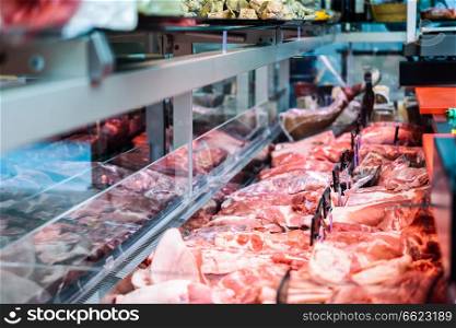 Fresh raw red meat at the butcher in refrigerated display