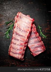Fresh raw ribs on the table. On a rustic dark background. High quality photo. Fresh raw ribs on the table.
