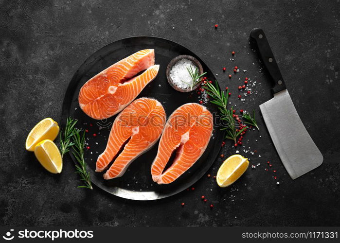 Fresh raw salmon fish steaks with cooking ingredients on kitchen table, healthy food, source of omega-3