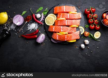Fresh raw salmon red fish fillet on black background. Top view