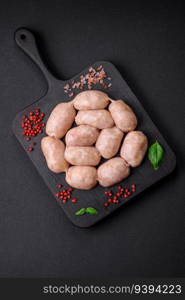 Fresh raw sausages from pork or chicken with salt, spices and herbs on a textured concrete background