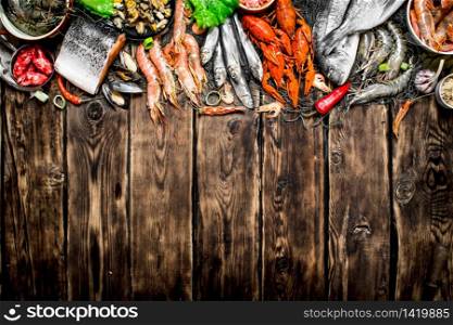 Fresh raw seafood. A variety of seafood on a fishing net. On wooden background.. variety of seafood on a fishing net.