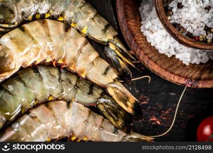 Fresh raw shrimp with spices. On a rustic dark background. High quality photo. Fresh raw shrimp with spices.