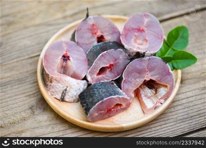 Fresh raw Snake head fish menu freshwater fish, Snakehead fish for cooking food, striped snakehead fish chopped with ingredients kaffir lime leaves on plate and wooden table kitchen background