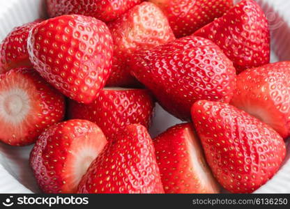 Fresh raw strawberries in a white porcelain dish