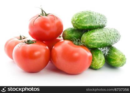 Fresh raw tomatoes and cucumbers over a white background