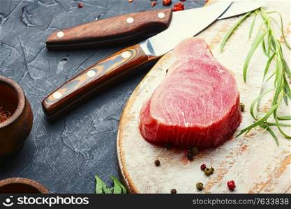 Fresh raw tuna steak on kitchen board. Raw tuna steak