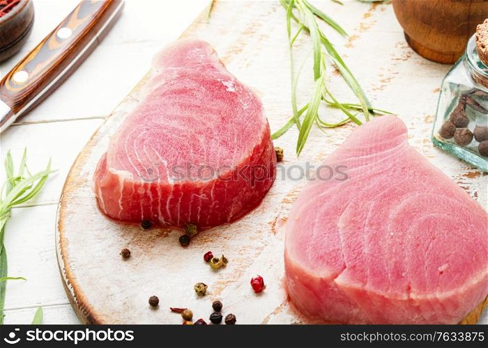 Fresh raw tuna steak on on cutting board.. Fresh tuna fish steak
