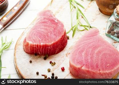 Fresh raw tuna steak on on cutting board.. Fresh tuna fish steak