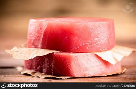 Fresh raw tuna steak on the table. On a wooden background. High quality photo. Fresh raw tuna steak on the table.
