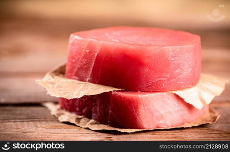 Fresh raw tuna steak on the table. On a wooden background. High quality photo. Fresh raw tuna steak on the table.