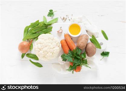 Fresh raw vegetables on white kitchen table, culinary background, top view