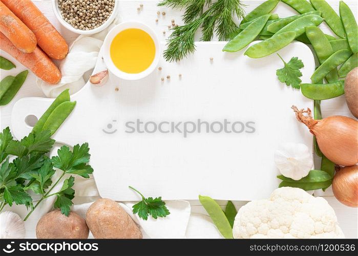 Fresh raw vegetables on white kitchen table, culinary background, top view