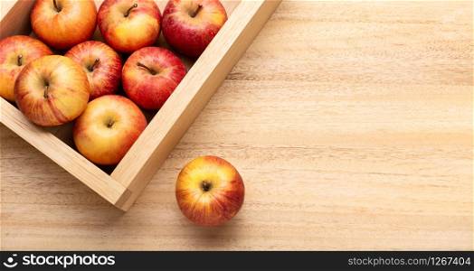 Fresh red apple background with copy space. Apples in crate on wooden table. Fuji apple