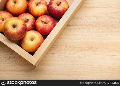 Fresh red apple background with copy space. Apples in crate on wooden table. Fuji apple