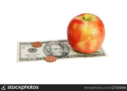 Fresh red apple on twenty dollar bill with coins isolated