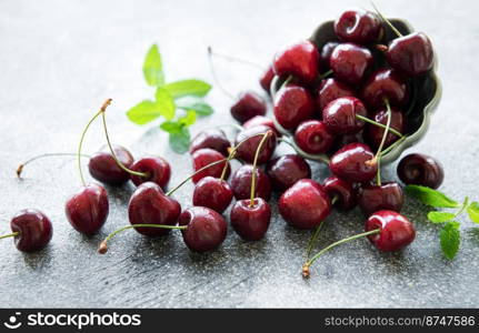 Fresh red cherries fruit in bowl on a concrete background