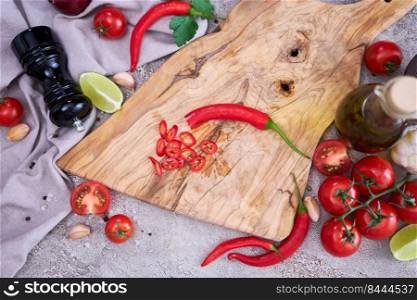 Fresh red chili peppers round slices on wooden cutting board at domestic kitchen.. Fresh red chili peppers round slices on wooden cutting board at domestic kitchen