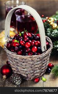 Fresh red cranberries in a basket with juice, spices and pine branches