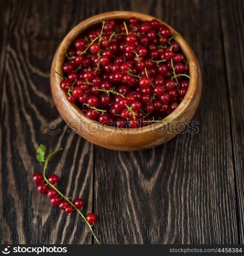 Fresh red currants. Fresh red currants in plate on wooden table