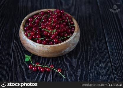 Fresh red currants in plate on wooden table. Fresh red currants