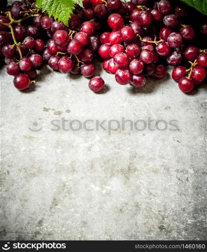 Fresh red grapes. On the stone table.. Fresh red grapes.