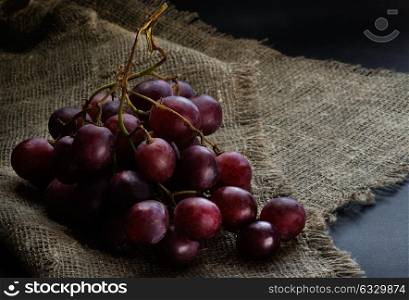 Fresh red grapes over rustic background, selective focus