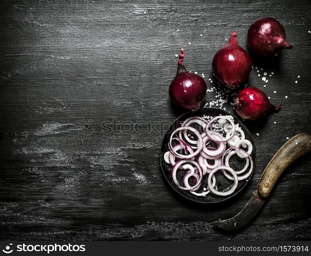 Fresh red onion cut into rings. On black rustic background.. Fresh red onion cut into rings.