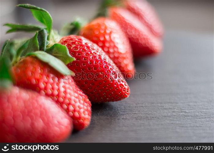 Fresh red strawberries on a black stone table