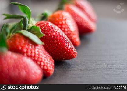 Fresh red strawberries on a black stone table