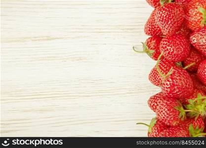 Fresh red strawberries on a white wooden background, banner, flat lay, mockup with copy space for text. Natural food frame.. Strawberry on white wooden background