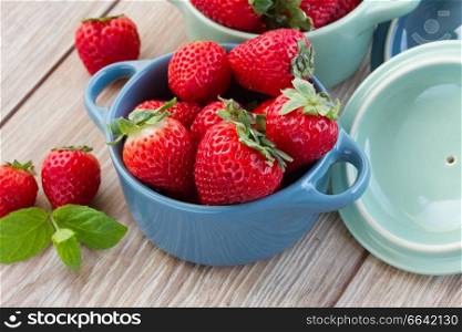 fresh red strawberry in bowl  and on a kitchen table close up
