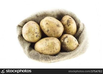 Fresh red tomato. potatoes in burlap sack isolated on white background .