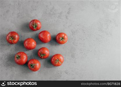 Fresh red tomatoes with water drops isolated over grey background with copy space. Natural organic food containing vitamins
