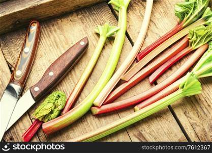 Fresh rhubarb stem on old wooden table.Food concept. Rhubarb stems on wooden surface