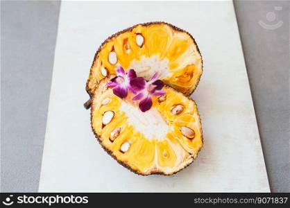 Fresh ripe jackfruit. Tropical fruit with purple orchids on it. Jackfruit segment ready to eat. Organic food. White background. Healthy eating concept