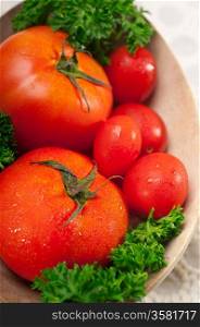 fresh ripe organic tomatoes on a wood bowl with parsley