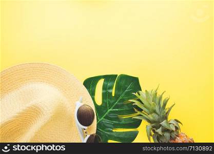 Fresh ripe pineapple glasses hat and leaf of monstera tree on color background, top view