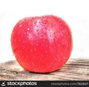 Fresh ripe red apple on wood table over white background.