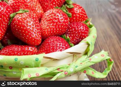 Fresh ripe strawberries in basket on a brown wooden background. Fresh red strawberries in basket 