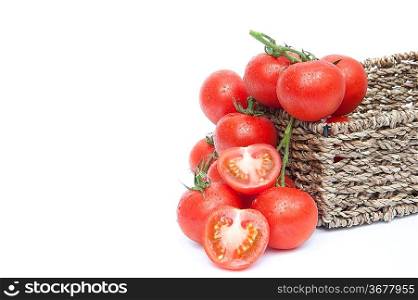 Fresh ripe vine tomatoes in rustic basket with sliced tomato isolated on white background
