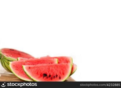 fresh ripe watermelon sliced on a wood table over white background