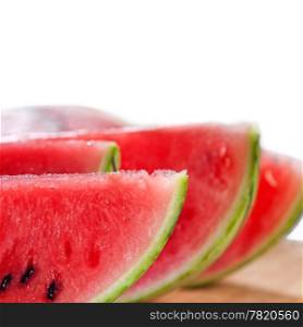 fresh ripe watermelon sliced on a wood table over white background