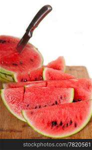 fresh ripe watermelon sliced on a wood table with knife over white background